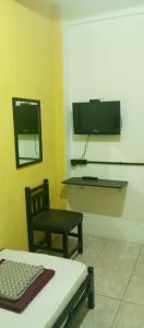 a room with a bed and a chair and a tv at PTS Homestay Syariah in Bandung