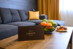 a table with a bowl of fruit and a sign on it at Libertè suites Velingrad in Velingrad