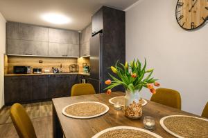 a kitchen and dining room with a table and a clock at Libertè suites Velingrad in Velingrad