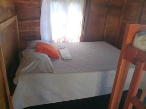 a small bedroom with two beds and a window at Cabaña los recuerdos de ella in Moñitos