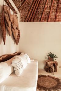 a bedroom with a bed with white sheets at Casa Chula Hotel Boutique Frente al Mar in Tierra Blanca