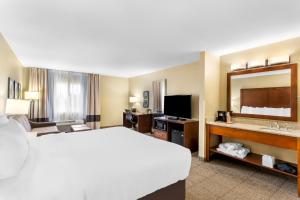 a hotel room with a bed and a large mirror at Comfort Inn & Suites Near University of Wyoming in Laramie