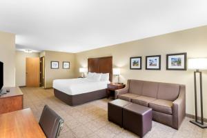 a hotel room with a bed and a couch at Comfort Inn & Suites Near University of Wyoming in Laramie +50 photos