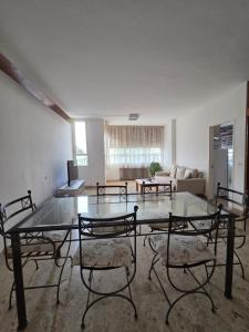 an empty room with a glass table and chairs at Casa LIDIA Hostel in Comodoro Rivadavia