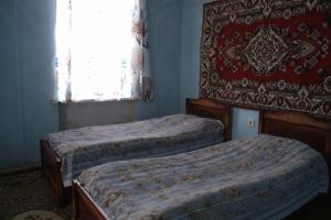 une chambre avec deux lits et une fenêtre avec un rideau dans l'établissement The Lichk Lodge, à Lichkʼ