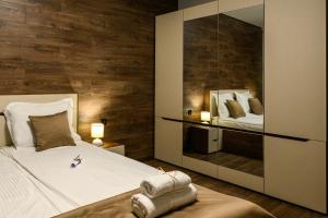 a bedroom with a bed and a mirror at Libertè suites Velingrad in Velingrad