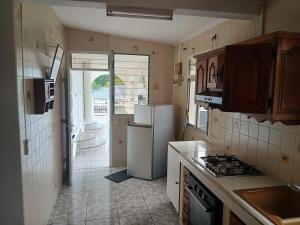 a kitchen with a refrigerator and a stove top oven at Haut de Villa Manguier in Petit-Bourg