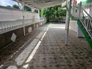 an empty walkway in a building with a fence at Haut de Villa Manguier in Petit-Bourg