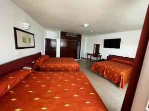 a hotel room with two beds and a flat screen tv at Hotel Royalty in Veracruz