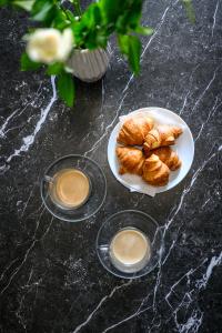 two plates of croissants and a plate of pastries on a table at Libertè suites Velingrad in Velingrad