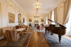 a room with a piano and a living room with chairs at Château La Rametière in Le PARC