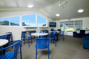 a room with tables and chairs and a couch at The Boathouse Lodge in Picton