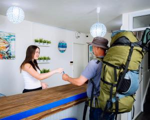 a man with a backpack shaking hands with a woman at The Boathouse Lodge in Picton