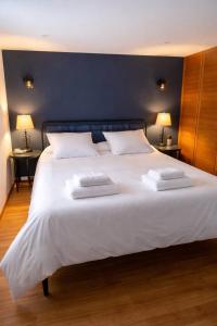a large white bed with two towels on it at Le Lavoir de Loches in Loches
