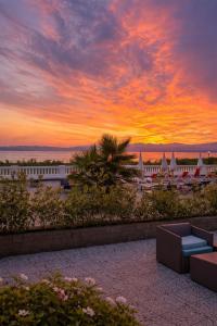 a sunset over a resort with a couch and a building at Hotel Villa Trieste in Sirmione