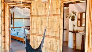 a hammock in a room with a bed and a bathroom at La Caleta Rooms in Mompiche