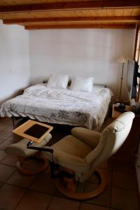 a bedroom with a bed and a chair and a table at El Balcón des Diablerets in Les Diablerets