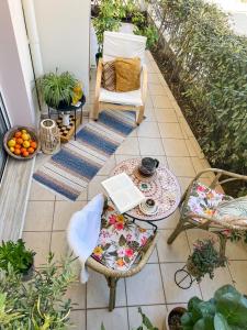 eine Terrasse mit einem Stuhl und einem Tisch mit einem Laptop in der Unterkunft Haplotēs Rhodes Apartment in Koskinou