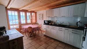 a kitchen with a table and a kitchen with a table and chairs at El Balcón des Diablerets in Les Diablerets