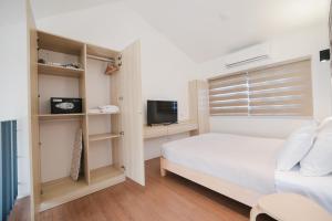 a small bedroom with a bed and a television at Casita Benito Loft D in Sangley Point Naval Station