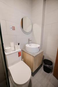 a bathroom with a white toilet and a sink at Casita Benito Loft D in Sangley Point Naval Station