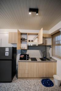 a kitchen with a black refrigerator and a sink at Casita Benito Loft D in Sangley Point Naval Station