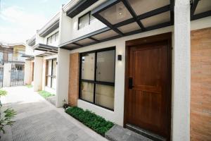 a house with a wooden door on the side of it at Casita Benito Loft D in Sangley Point Naval Station
