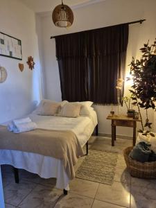 a bedroom with a large bed with a window at Mini Casa Tiradentes 2 in Tiradentes