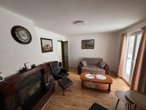 a living room with a couch and a clock on the wall at Planinska kuca Steki Bukulja in Arandelovac