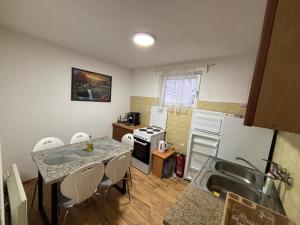 a kitchen with a table and chairs and a sink at Planinska kuca Steki Bukulja in Arandelovac