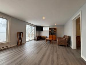 an empty living room with a couch and a chair at Beautiful Waterfront Apartment Quispamsis, NB in Catons Island
