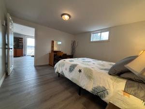 a bedroom with a large bed and a window at Beautiful Waterfront Apartment Quispamsis, NB in Catons Island