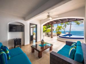 a living room with blue furniture and a view of the ocean at Marboka Hotel & Suites in Puerto Vallarta