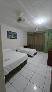 a hotel room with two beds and a window at La Paloma Hostal in Moyogalpa