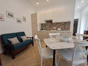 a kitchen and a living room with a table and a couch at Residenza Rivellini Tropea in Tropea