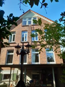 a brick house with a street light in front of it at BELETAGE in Emden