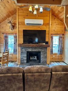 a living room with a fireplace and a tv at Creekside Blessings Cabin in Beech Mountain