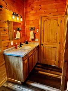 a bathroom with a sink and a mirror at Creekside Blessings Cabin in Beech Mountain +73 photos