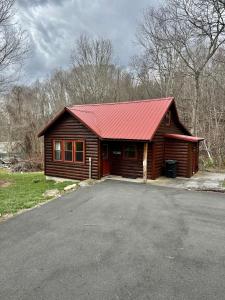 a small log cabin with a red roof at Creekside Blessings Cabin in Beech Mountain