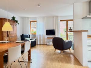 a kitchen and living room with a table and chairs at Ferienwohnung Im schönen Dorf - idyllische Lage mit Terrasse und Garten in Lindau-Bodolz