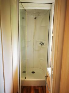 a shower with a glass door in a bathroom at Camping le Terriol - Onlycamp in Cajarc