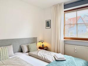 a bedroom with a bed and a window at Ferienwohnung Im schönen Dorf - idyllische Lage mit Terrasse und Garten in Lindau-Bodolz