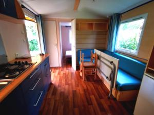 a kitchen with blue cabinets and a blue bench in it at Camping le Terriol - Onlycamp in Cajarc