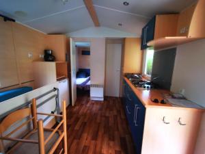 a kitchen with blue cabinets and a counter top at Camping le Terriol - Onlycamp in Cajarc