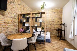 a room with a brick wall and a table and chairs at Residence 1892 - Apartment 3 in Bratislava