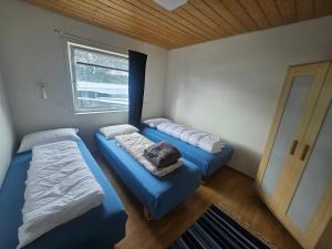 two beds in a room with a window at HOL Familie Hous in Hol