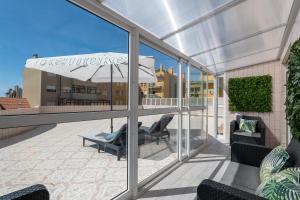 a patio with chairs and an umbrella on a balcony at Sunset Terrace House by Destiny Houses in Esmoriz