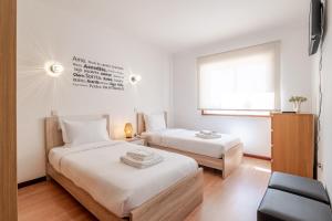 a bedroom with two beds and a window at Sunset Terrace House by Destiny Houses in Esmoriz