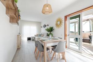 a dining room and living room with a table and chairs at Sunset Terrace House by Destiny Houses in Esmoriz
