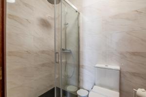 a shower with a glass door next to a toilet at Sunset Terrace House by Destiny Houses in Esmoriz +16 photos